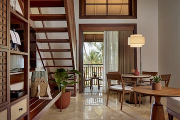 a room with a staircase and a table and chairs