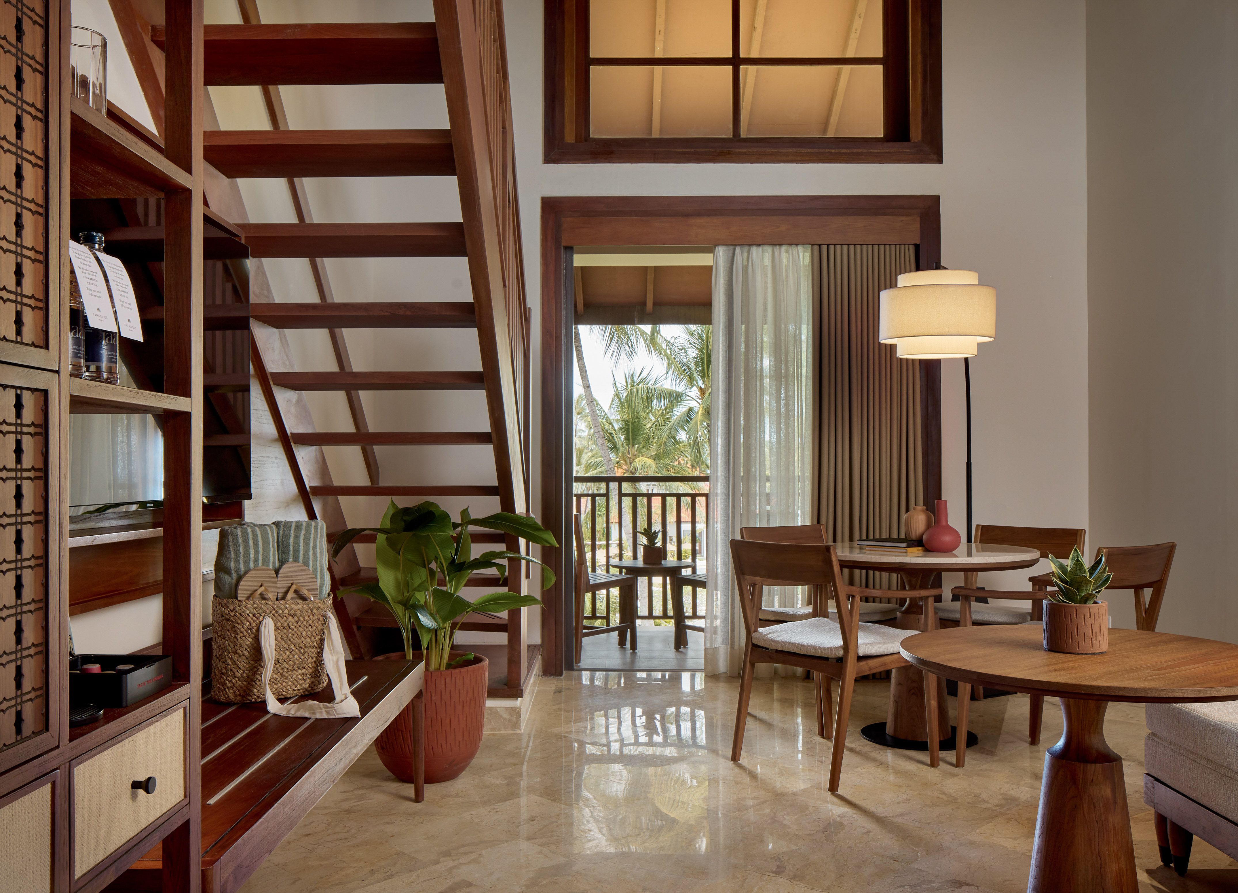 a room with a staircase and a table and chairs