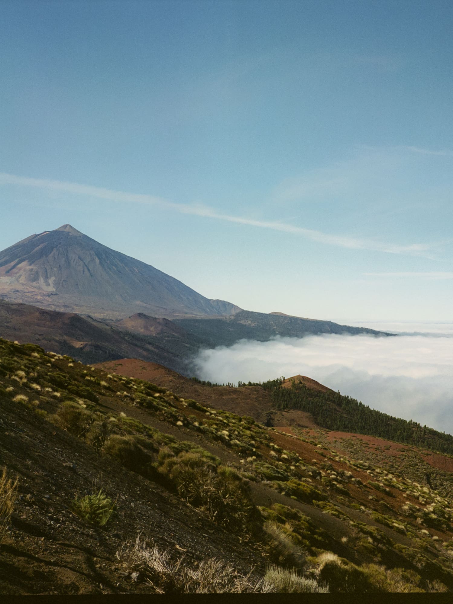 a mountain with a hill and clouds in the background