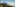 a mountain with a hill and clouds in the background