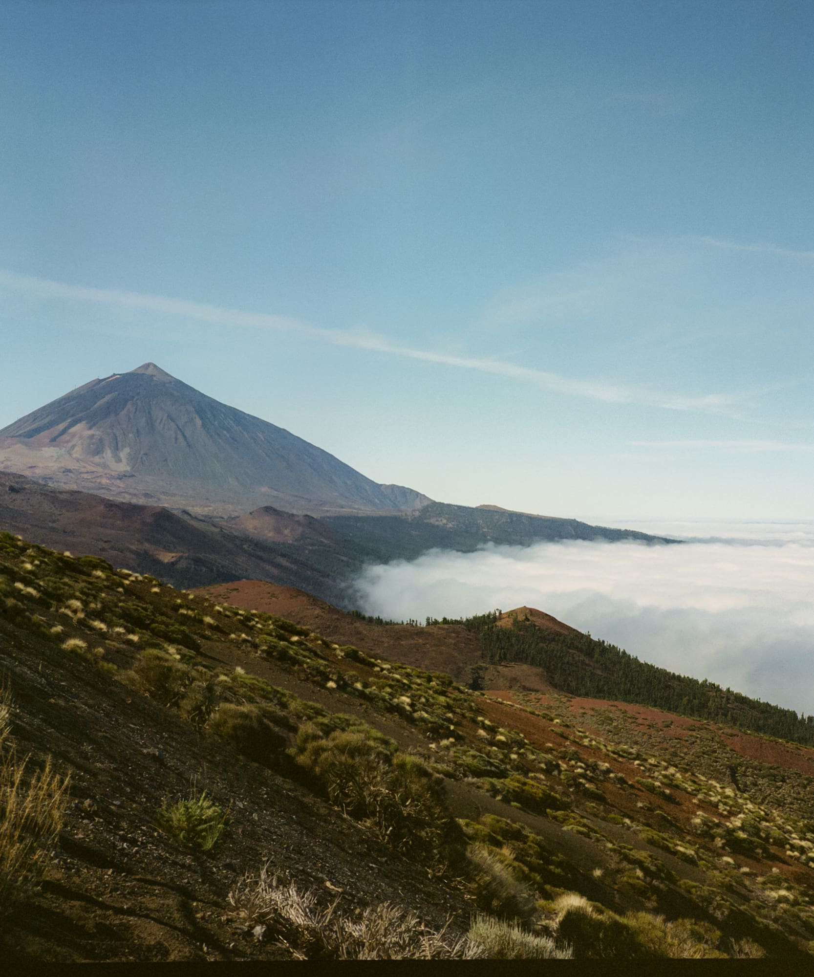 a mountain with a hill and clouds in the background