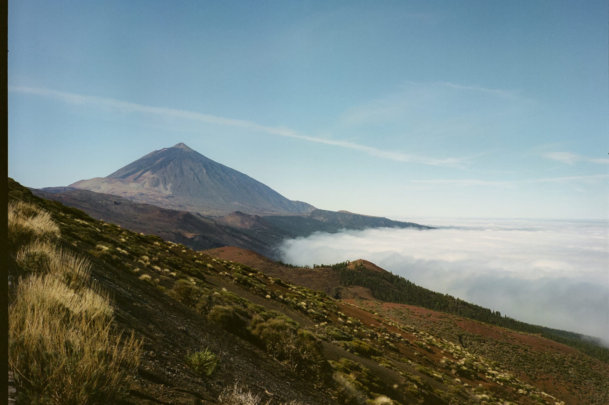 a mountain with a hill and clouds in the background