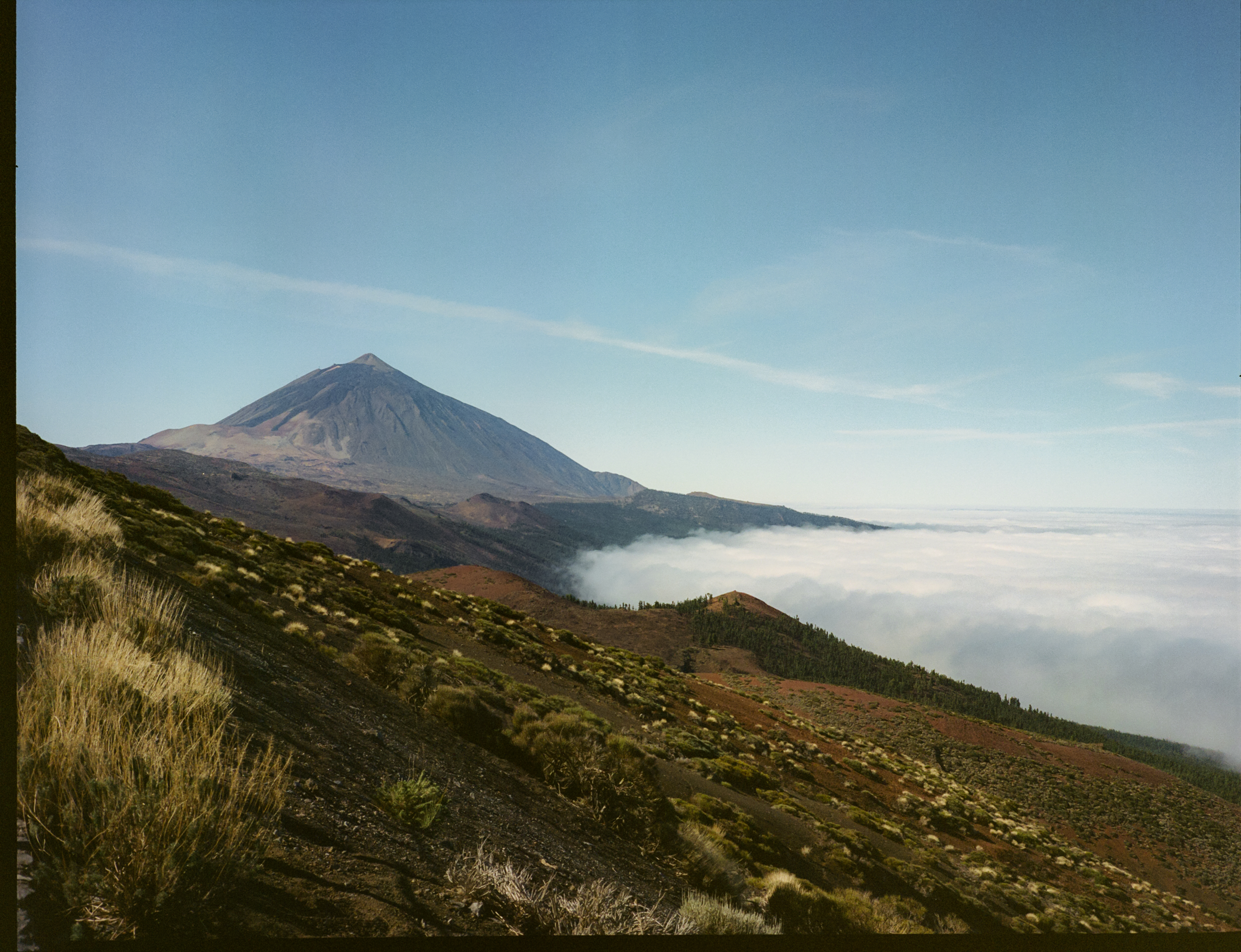 a mountain with a hill and clouds in the background