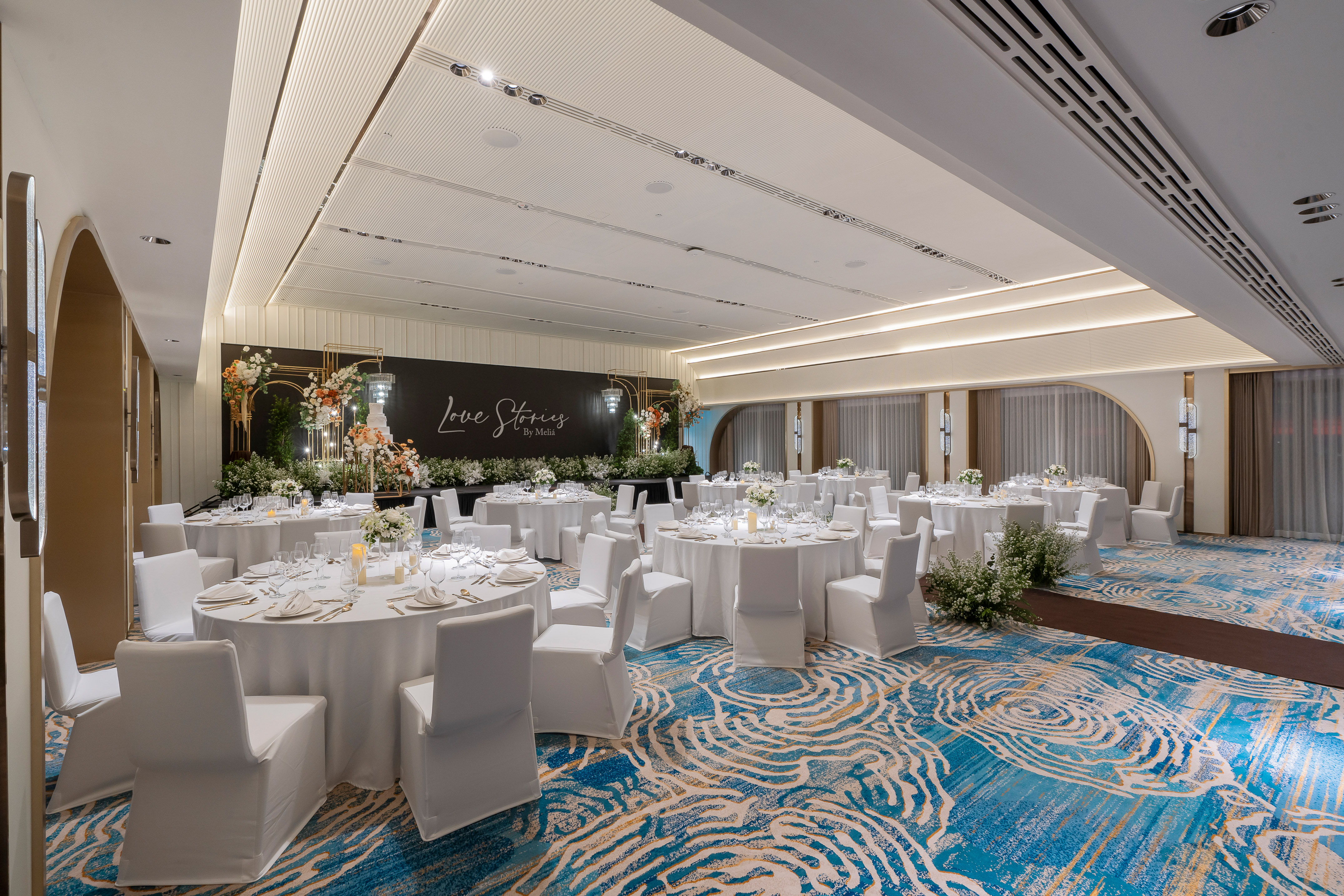 Meliá wedding ballroom with elegant white tables, floral decor, and blue carpet. - Nuaan - Meliá Pattaya Hotel, Pattaya