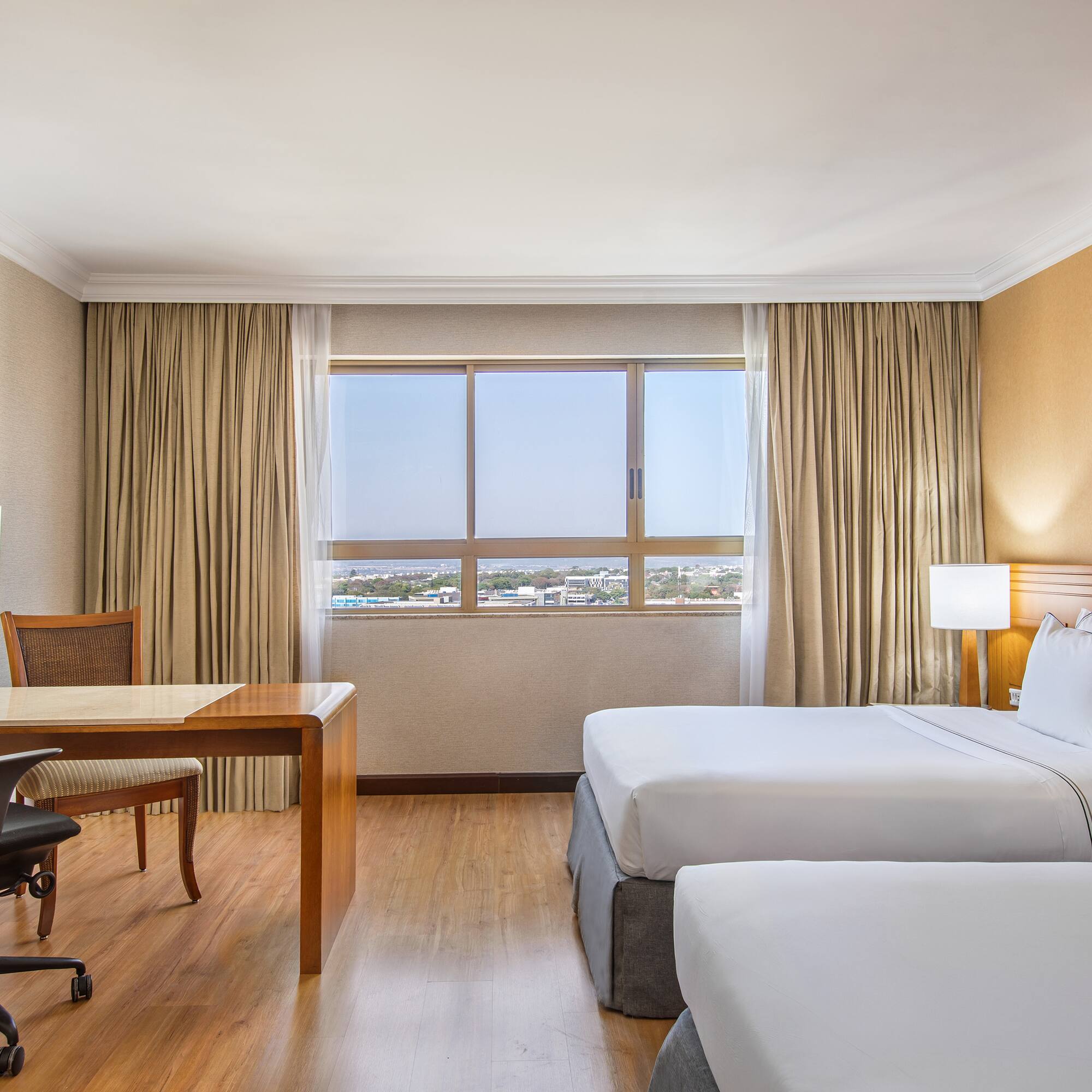 a room with two beds and a desk