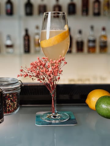 a glass of liquid with a lemon slice in it