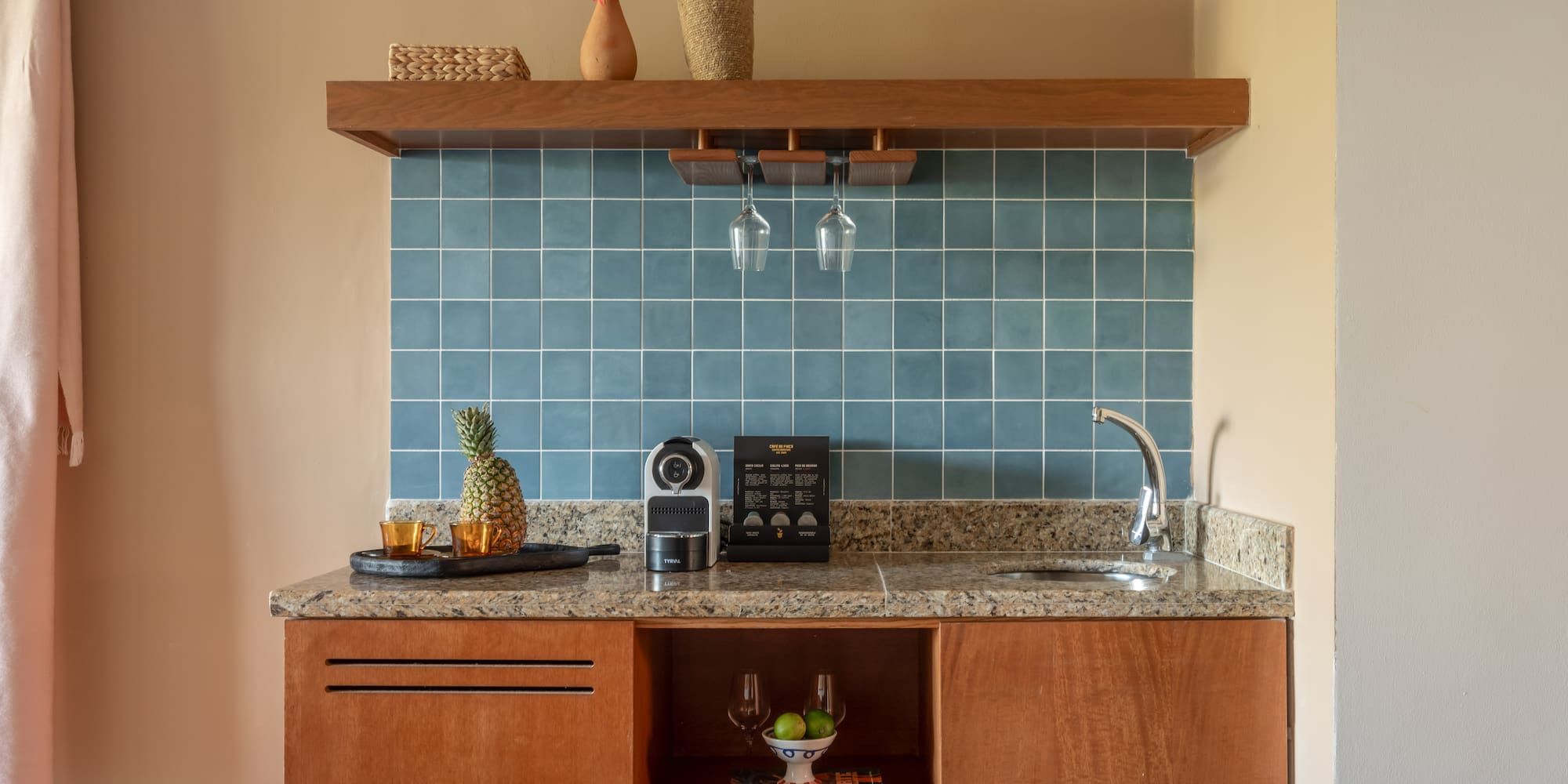 a kitchen counter with a sink and a shelf