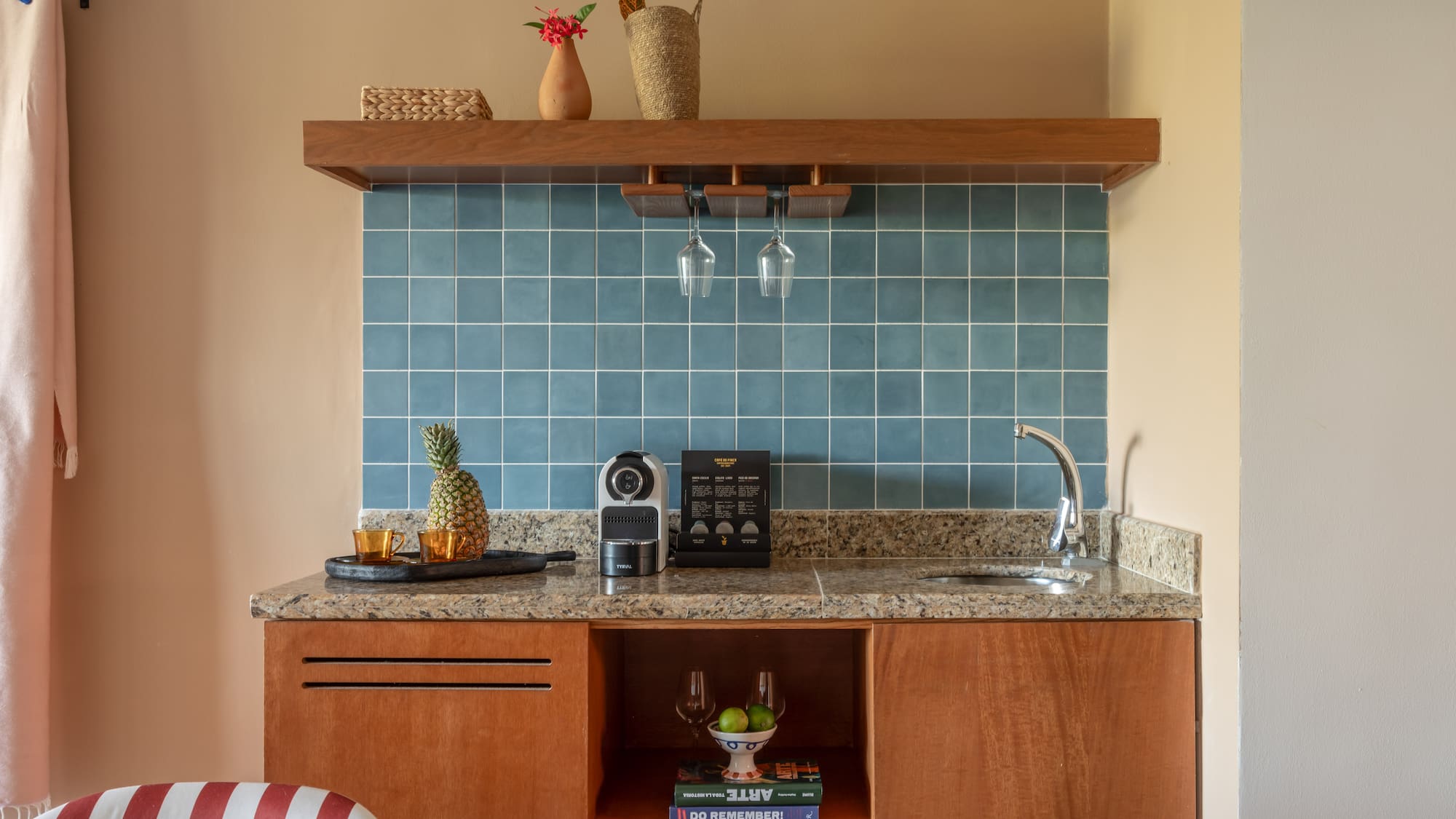 a kitchen counter with a sink and a shelf