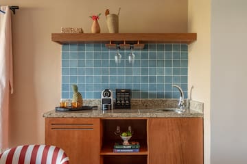 a kitchen counter with a sink and a shelf
