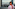 New York City skyline with One World Trade Center, blurred woman, red scarf.