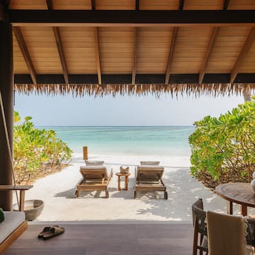 a beach with chairs and a table on a beach