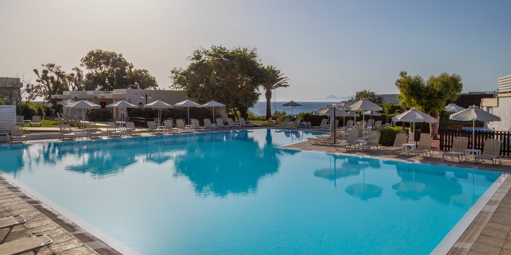 a swimming pool with umbrellas and chairs