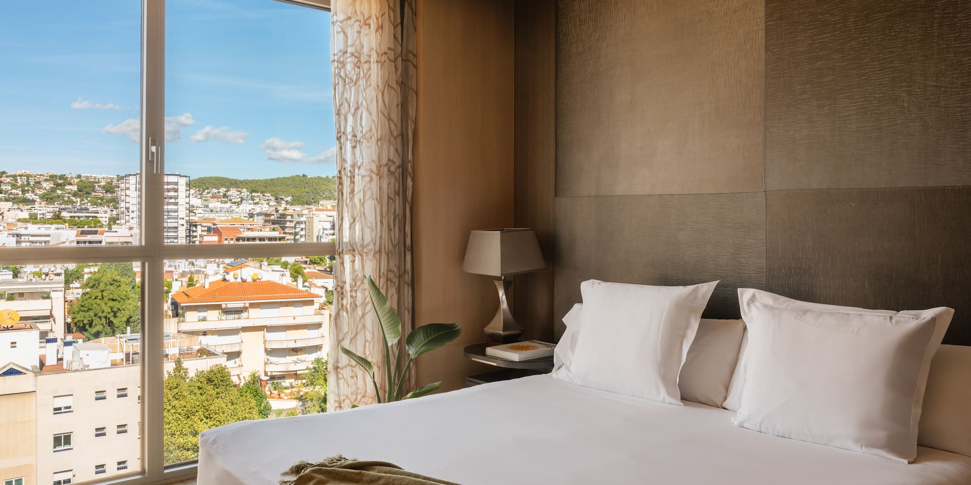 a bed with a window and a view of a city