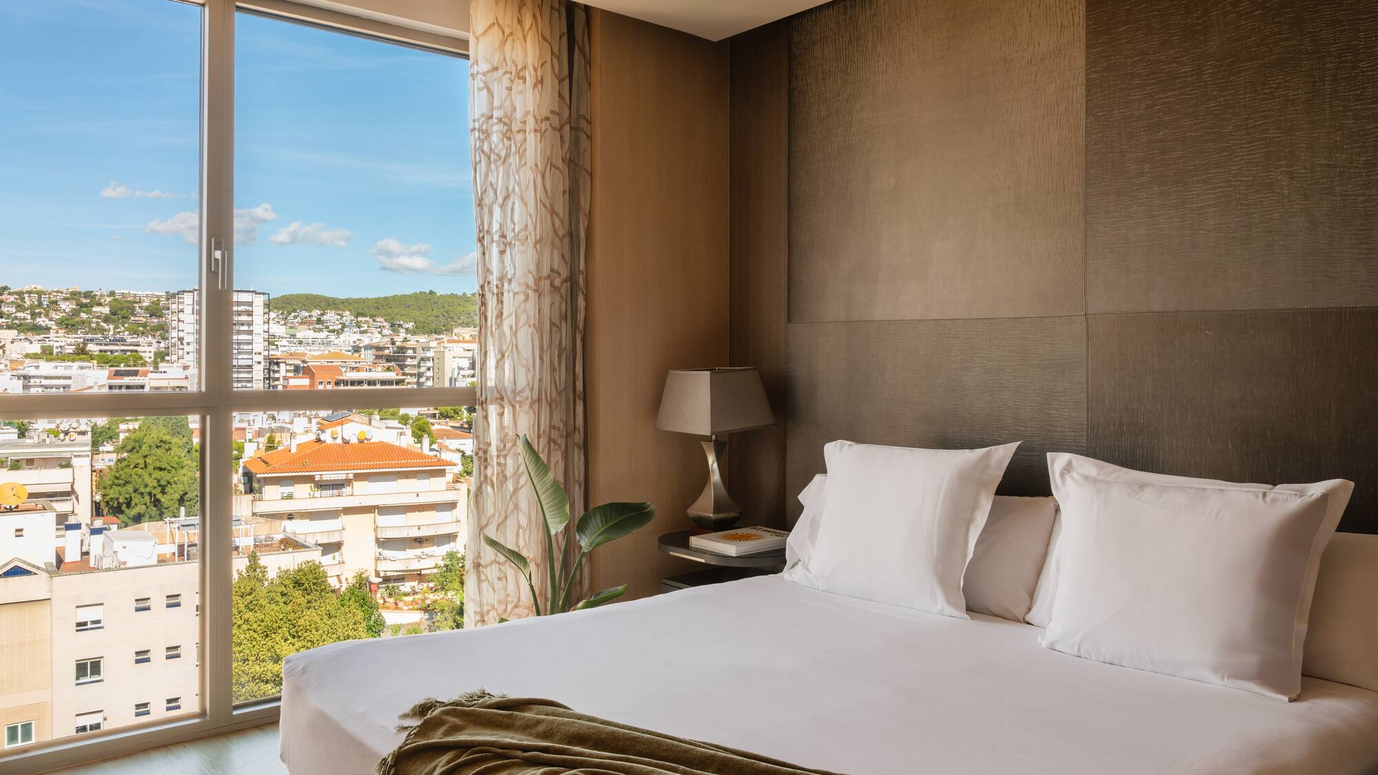 a bed with a window and a view of a city