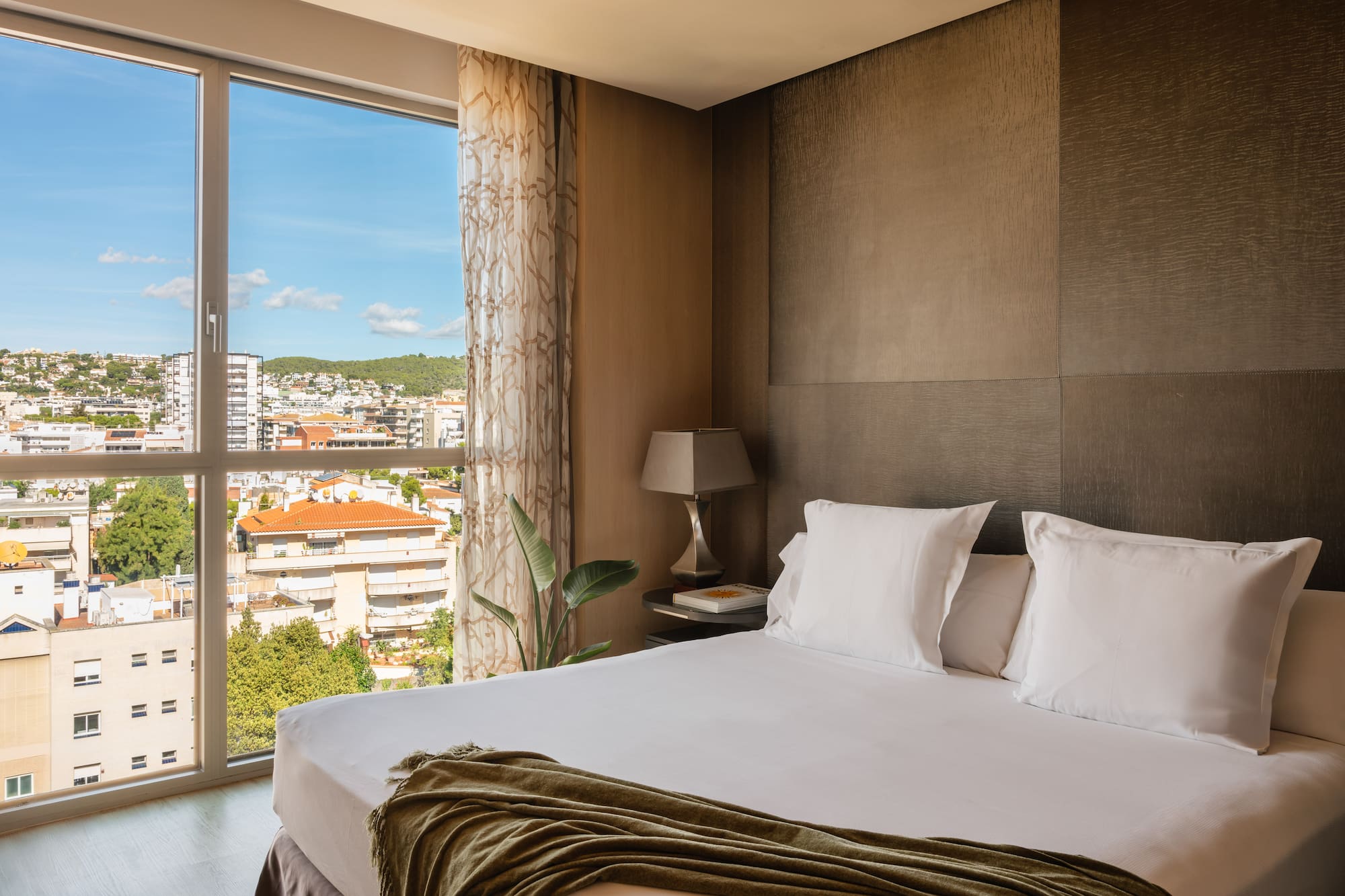 a bed with a window and a view of a city