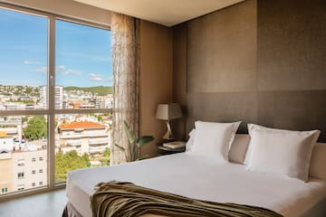 a bed with a window and a view of a city