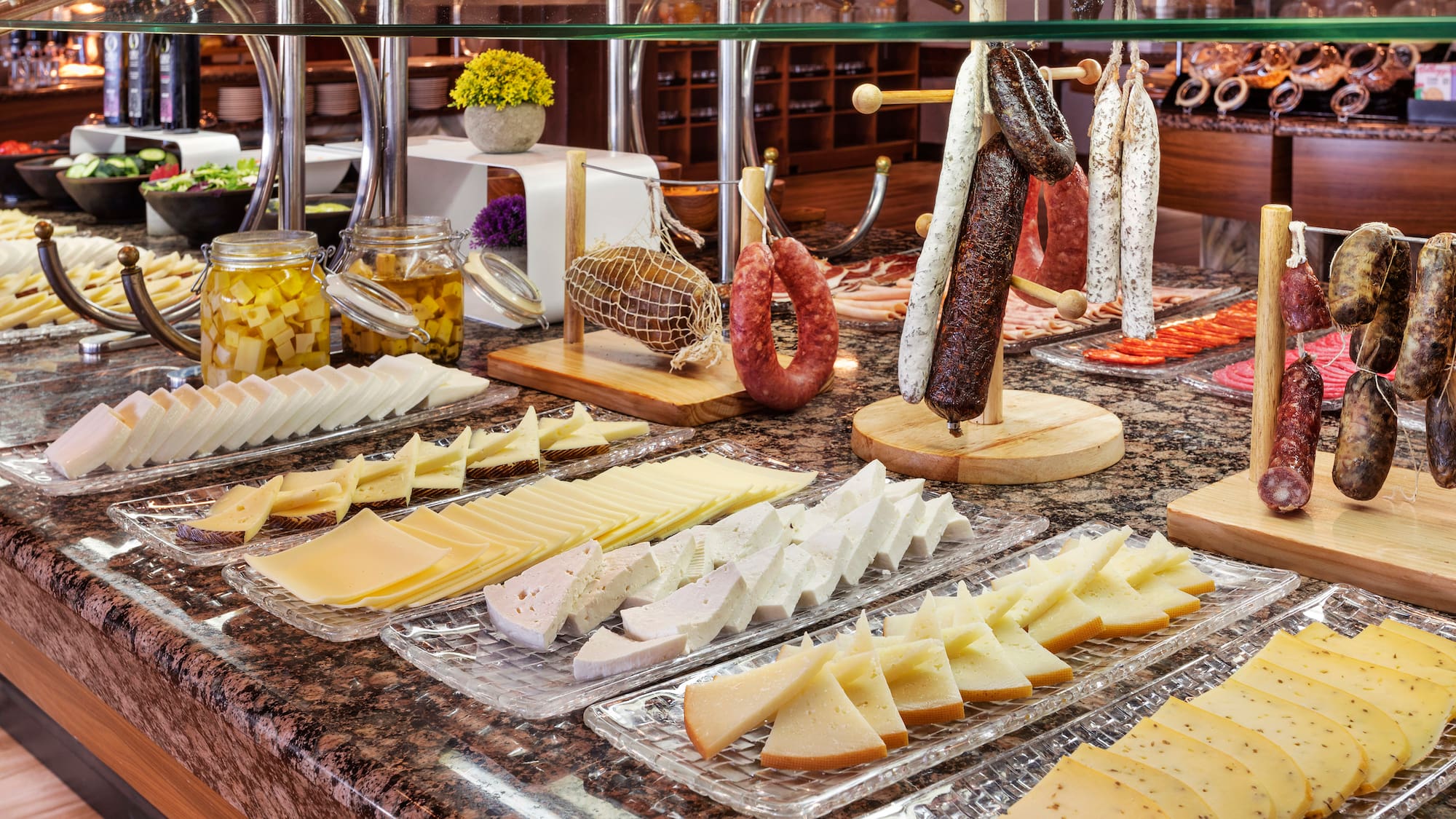 a counter with different types of cheese and sausages