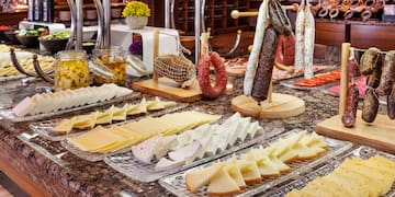 a counter with different types of cheese and sausages