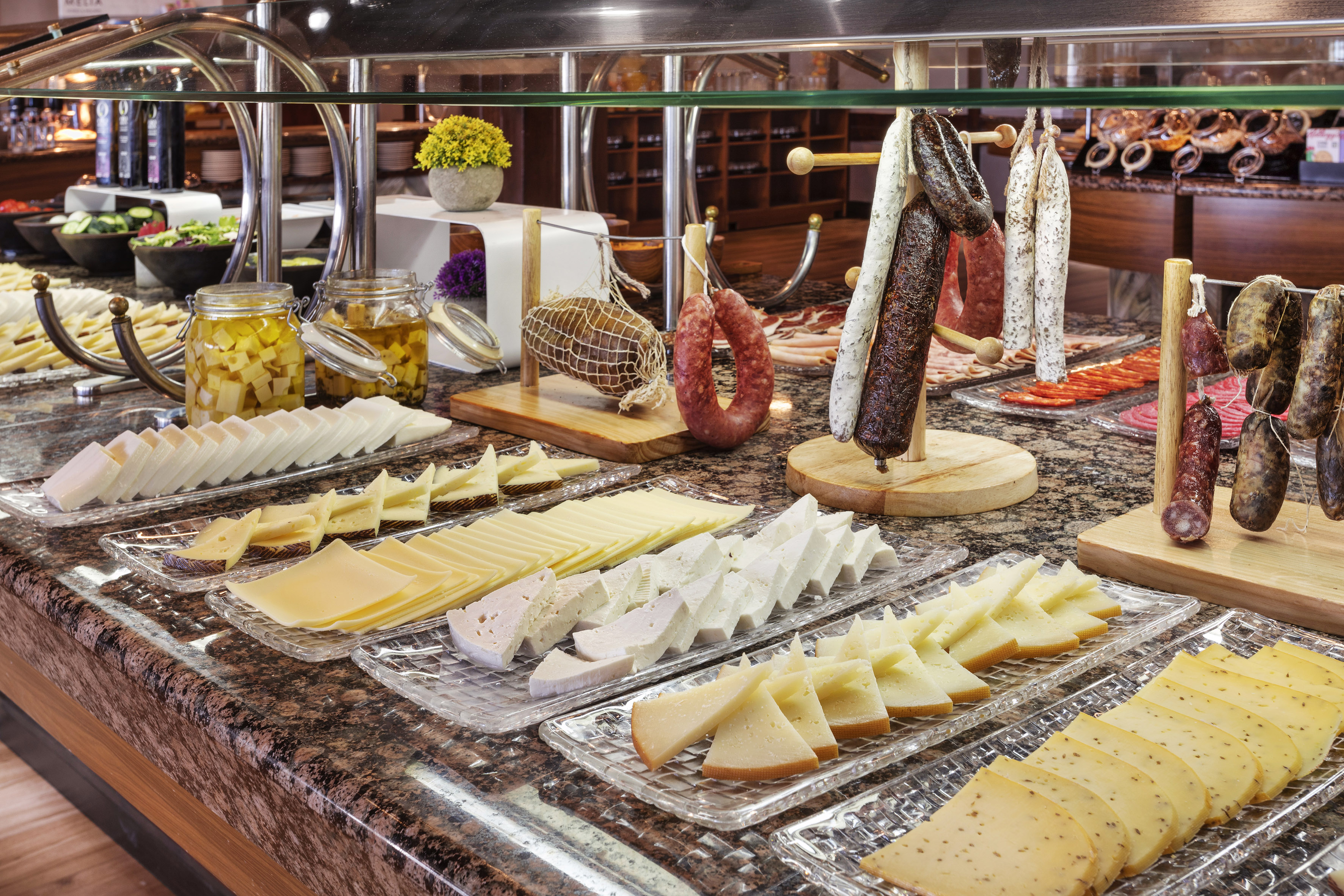 a counter with different types of cheese and sausages