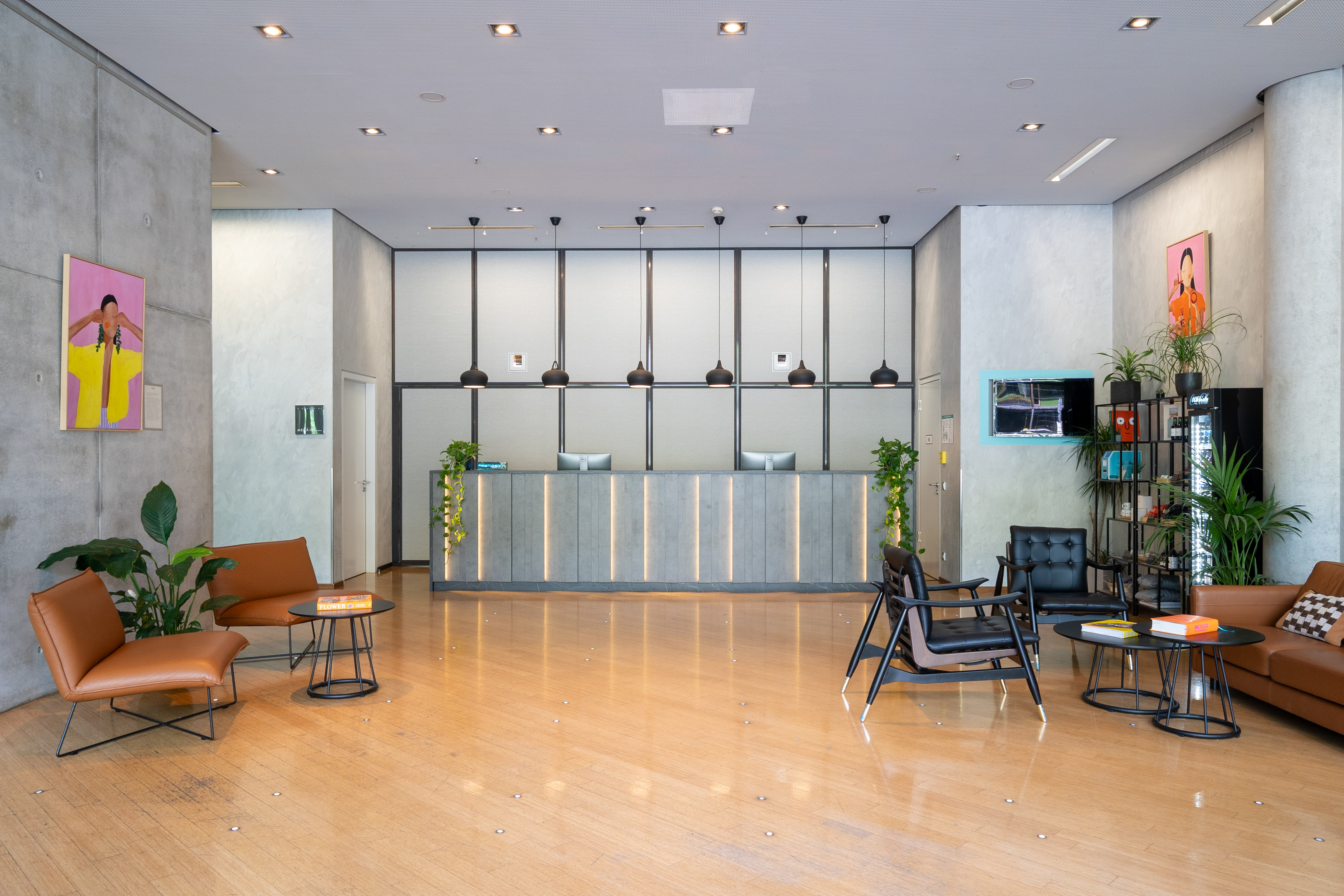Modern hotel lobby with sleek reception desk, wooden floor, and comfortable seating areas.