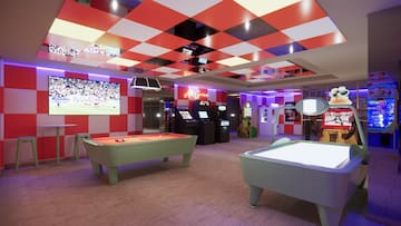 a room with a pool table and arcade games