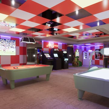 a room with a pool table and arcade games