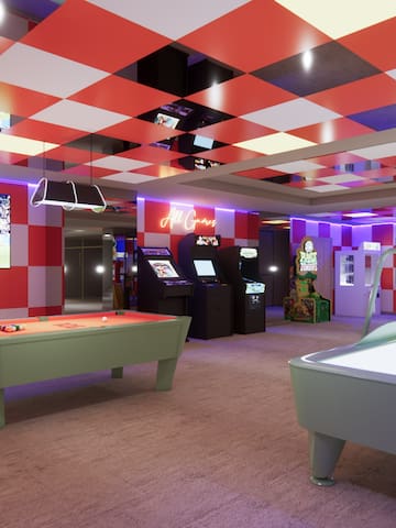 a room with a pool table and arcade games