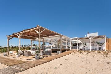 a white building with a wooden structure and a wooden walkway