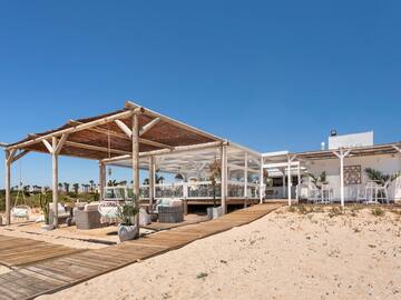 a white building with a wooden structure and a wooden walkway