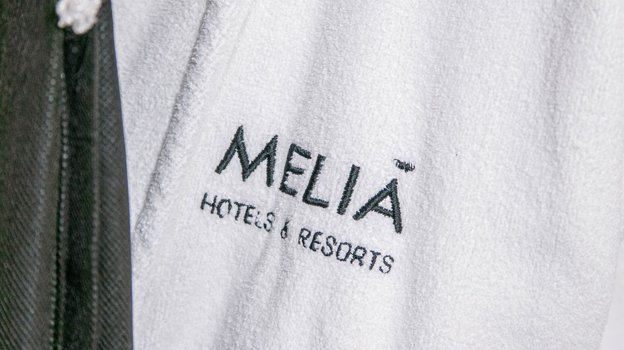 White Meliã Hotels & Resorts embroidered bathrobe, hotel amenity.