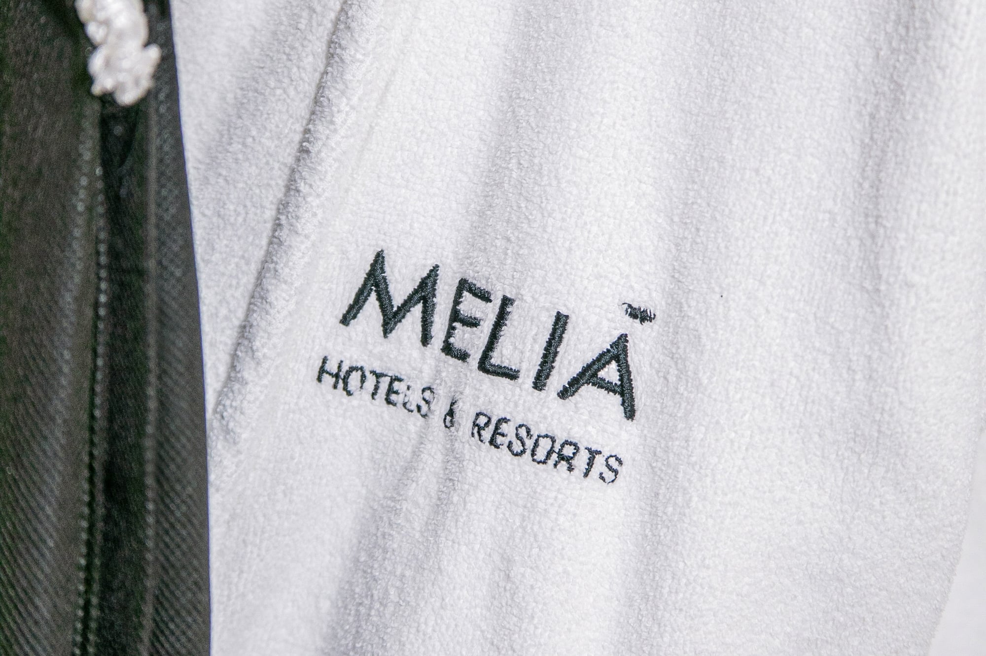 Meliã Hotels & Resorts logo embroidered on a white hotel bathrobe.