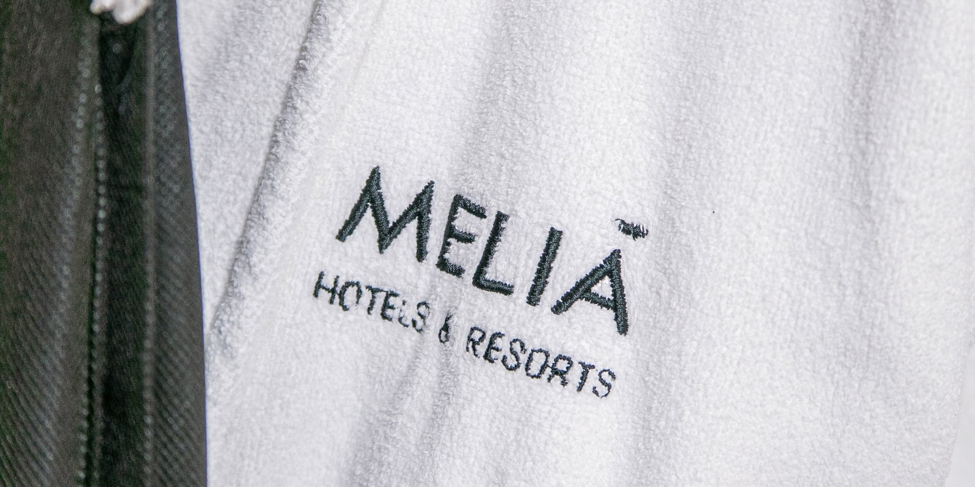 Meliã Hotels & Resorts logo embroidered on a white hotel bathrobe.