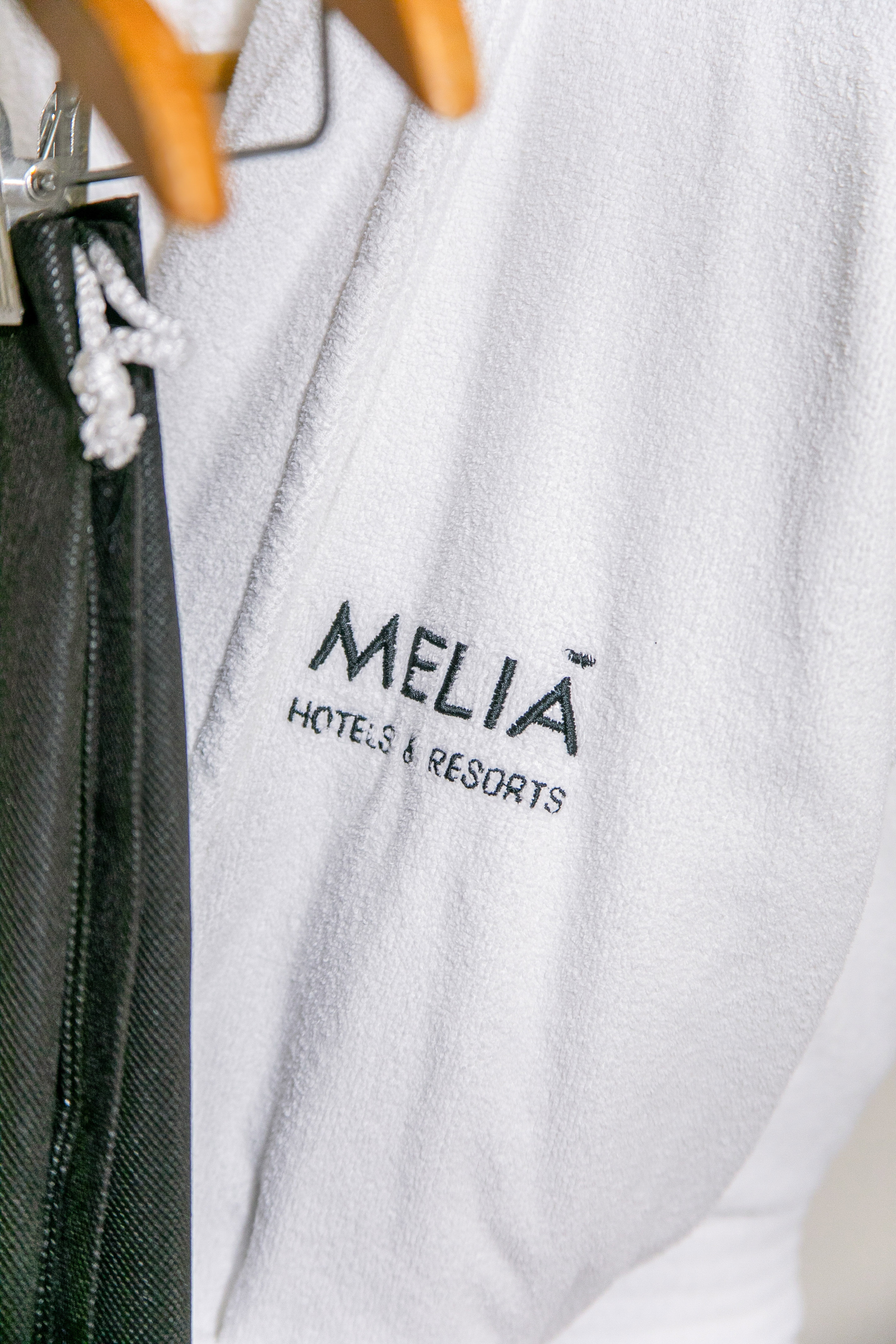Meliã Hotels & Resorts logo embroidered on a white hotel bathrobe.