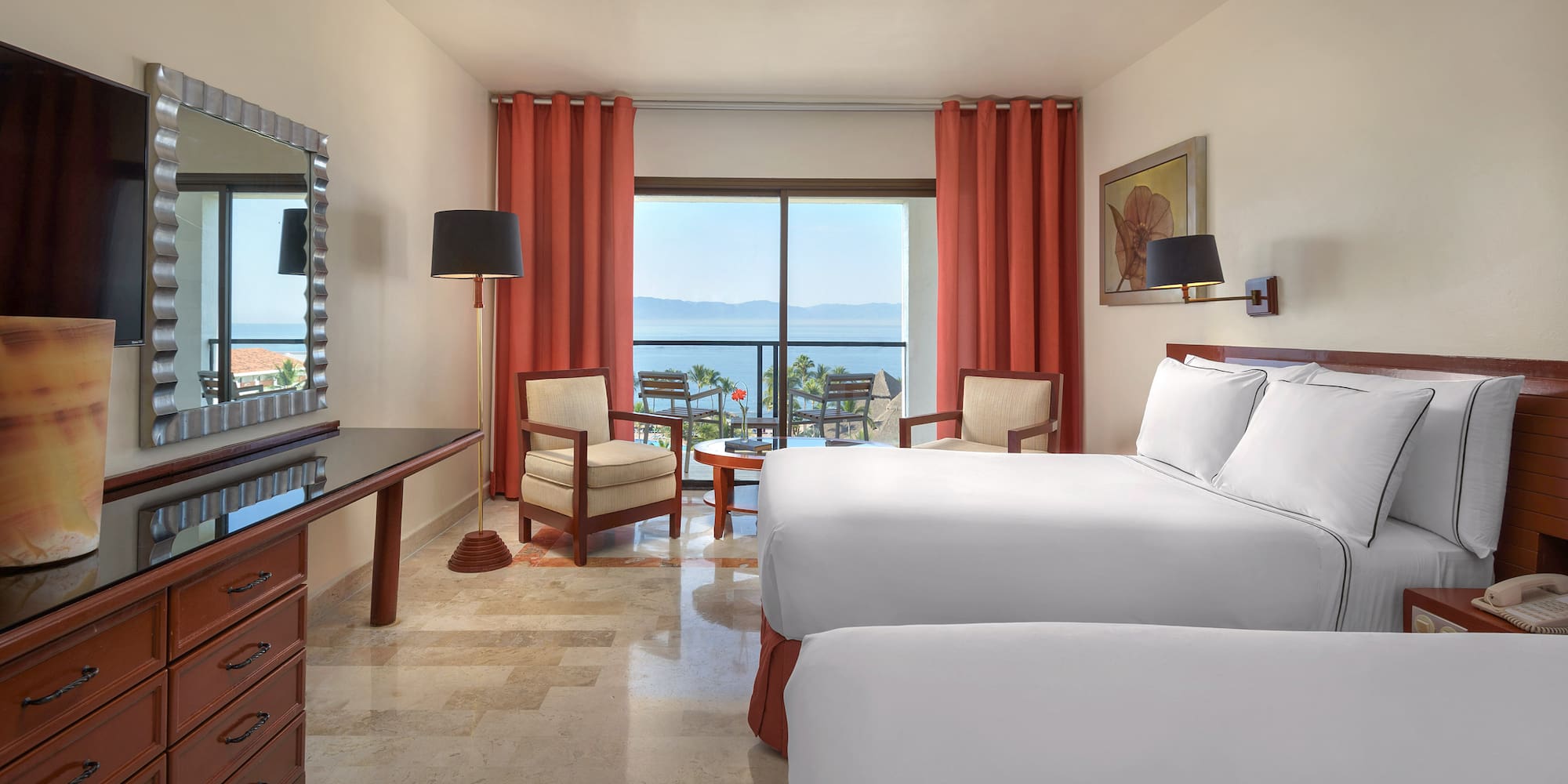 a room with two beds and a table and chairs