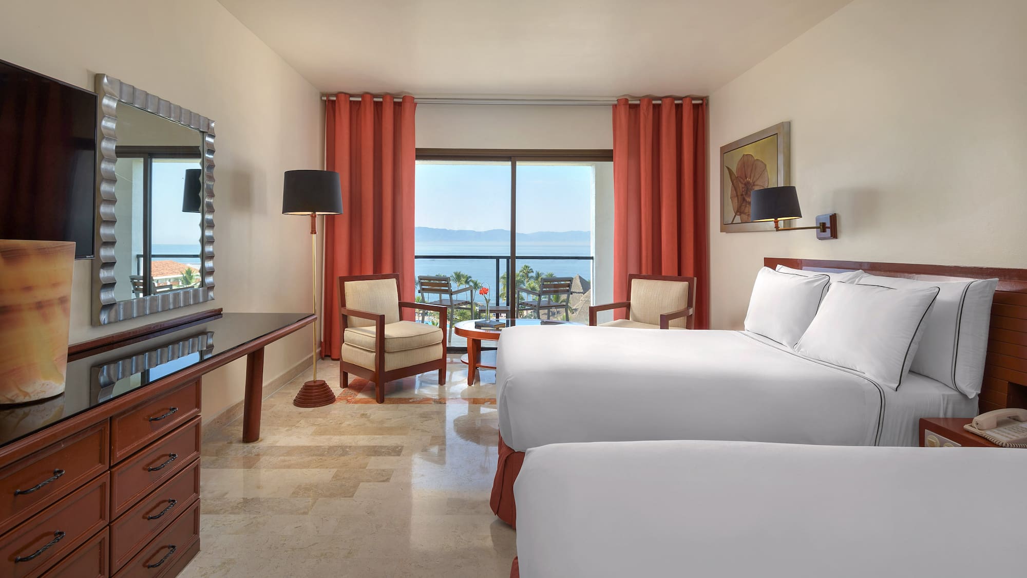 a room with two beds and a table and chairs