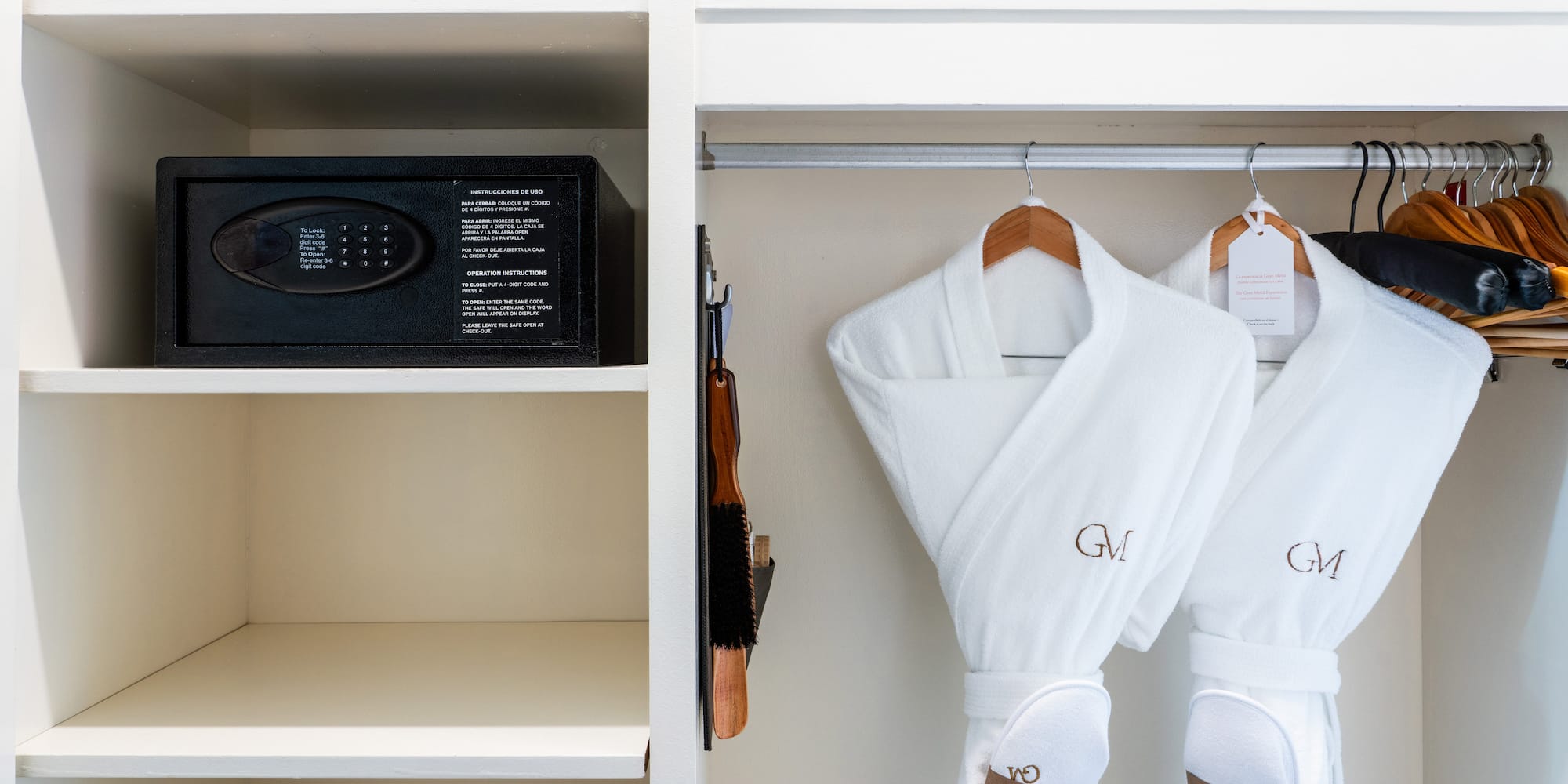 a white robe on a rack with a safe and a bed