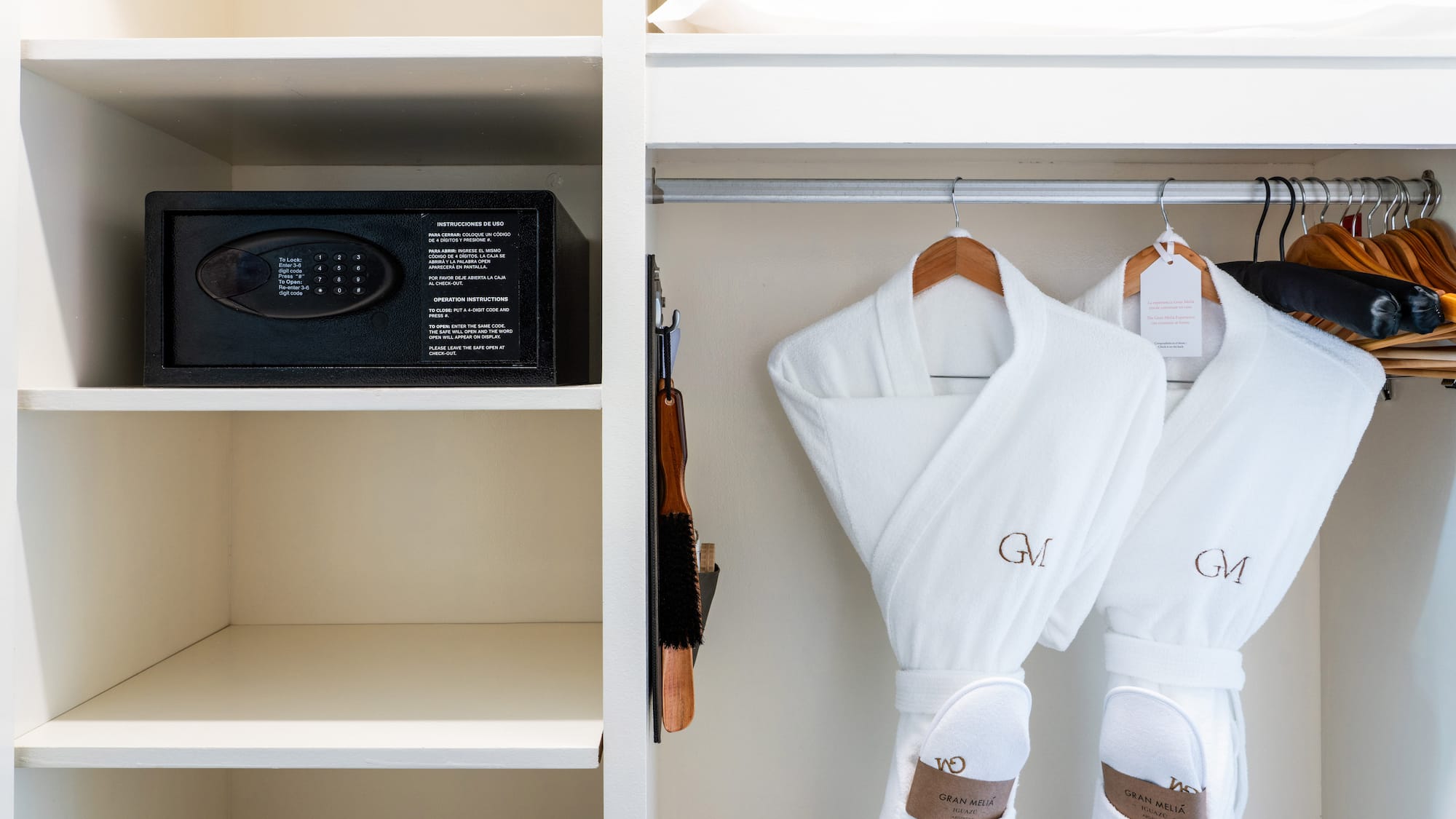 a white robe on a rack with a safe and a bed