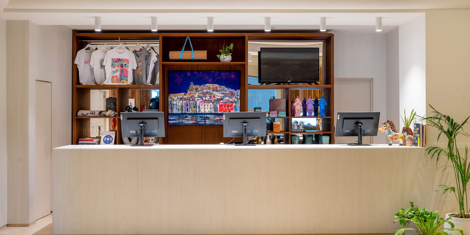 a counter with computers and a tv in front of it