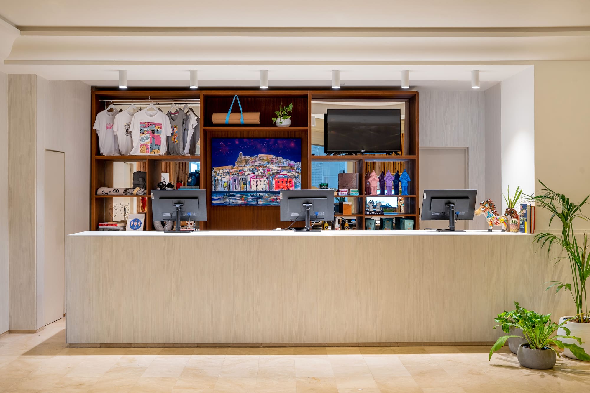 Reception counter with retail merchandise, computers, and vibrant artwork.