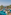Aerial view of tropical luxury resort pool, palm trees, and ocean.