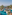 Aerial view of tropical luxury resort pool, palm trees, and ocean.