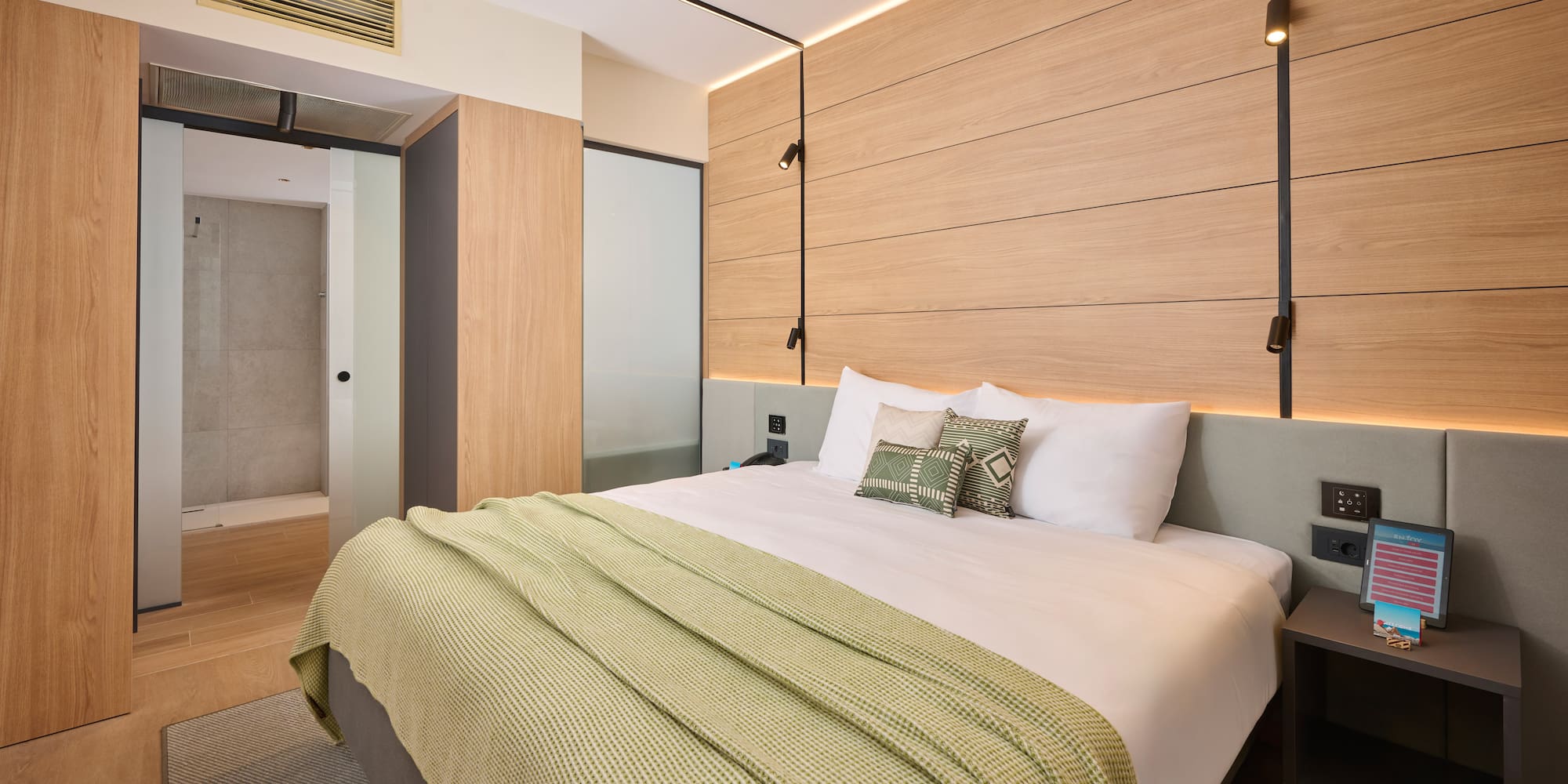 a bed with pillows and a bed with a wood paneled wall