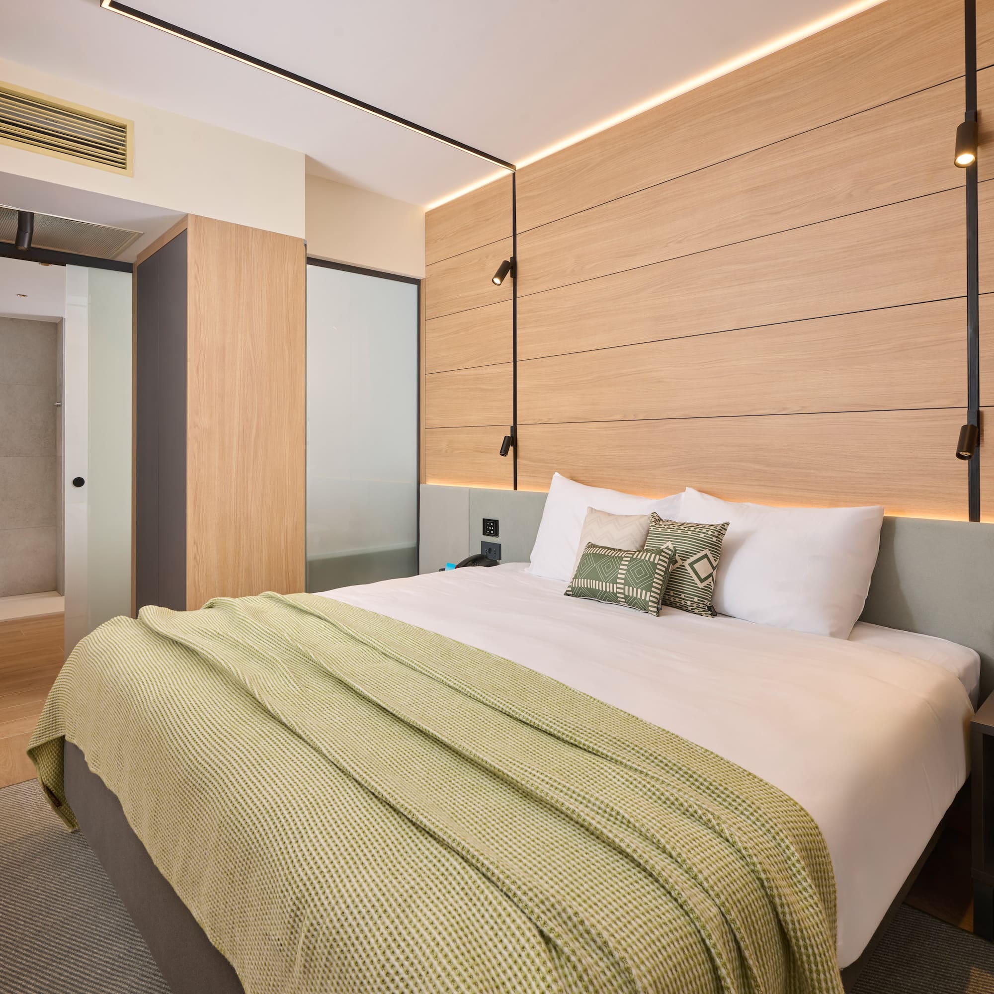 a bed with pillows and a bed with a wood paneled wall