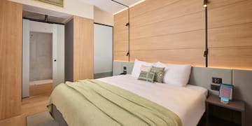 a bed with pillows and a bed with a wood paneled wall