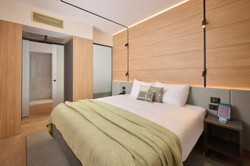 a bed with pillows and a bed with a wood paneled wall