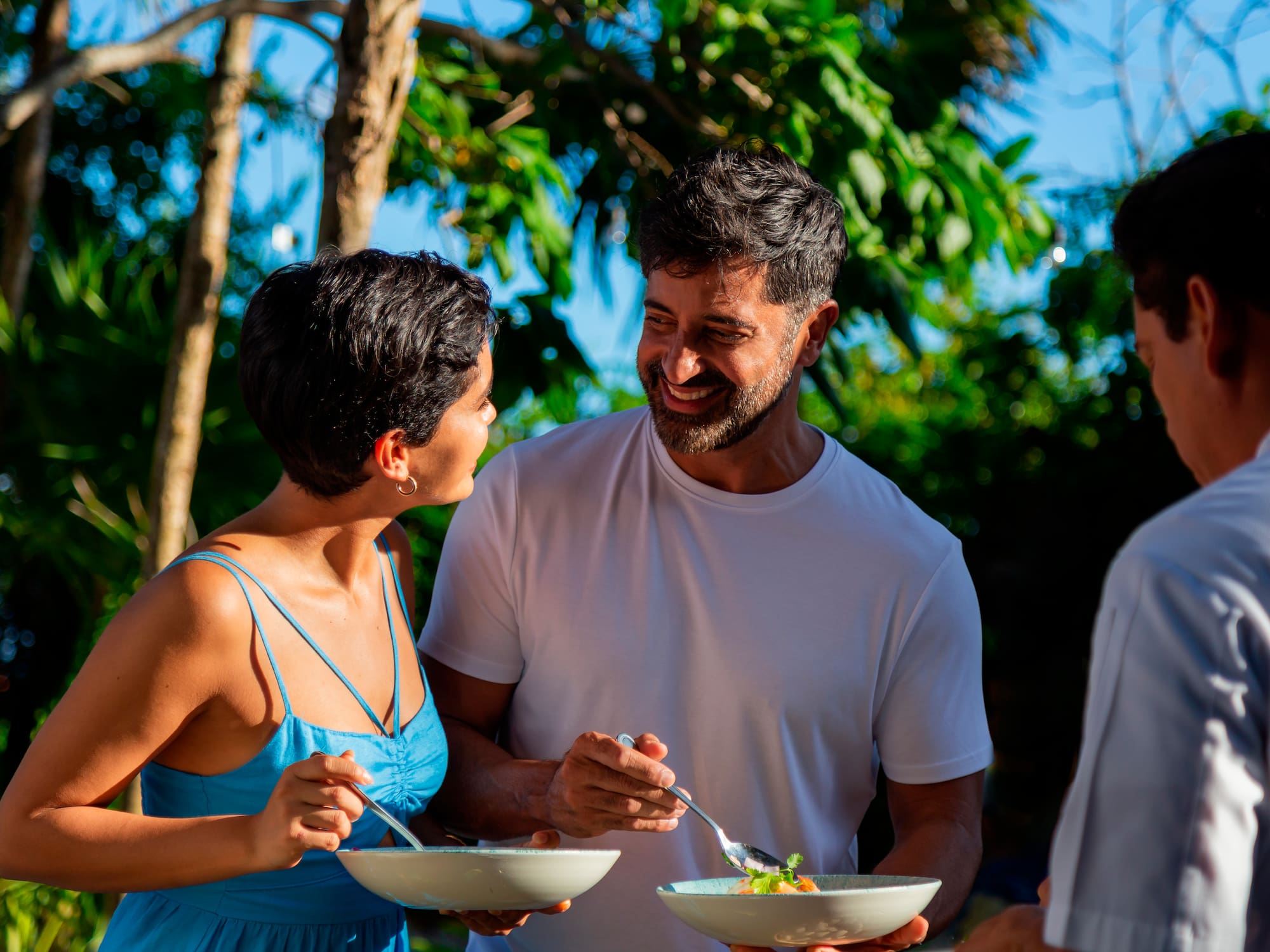 a man and woman smiling and eating food