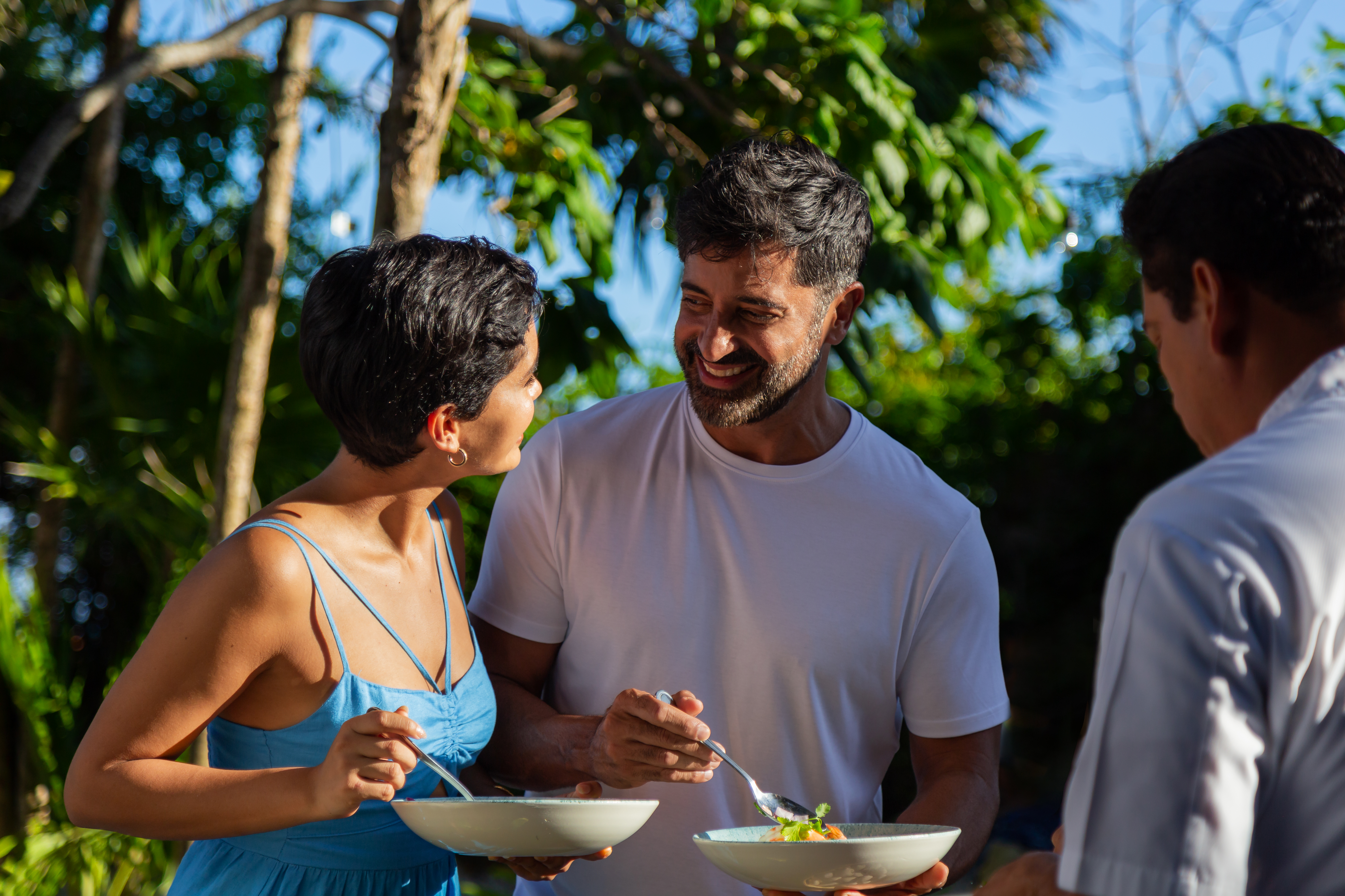 a man and woman smiling and eating food