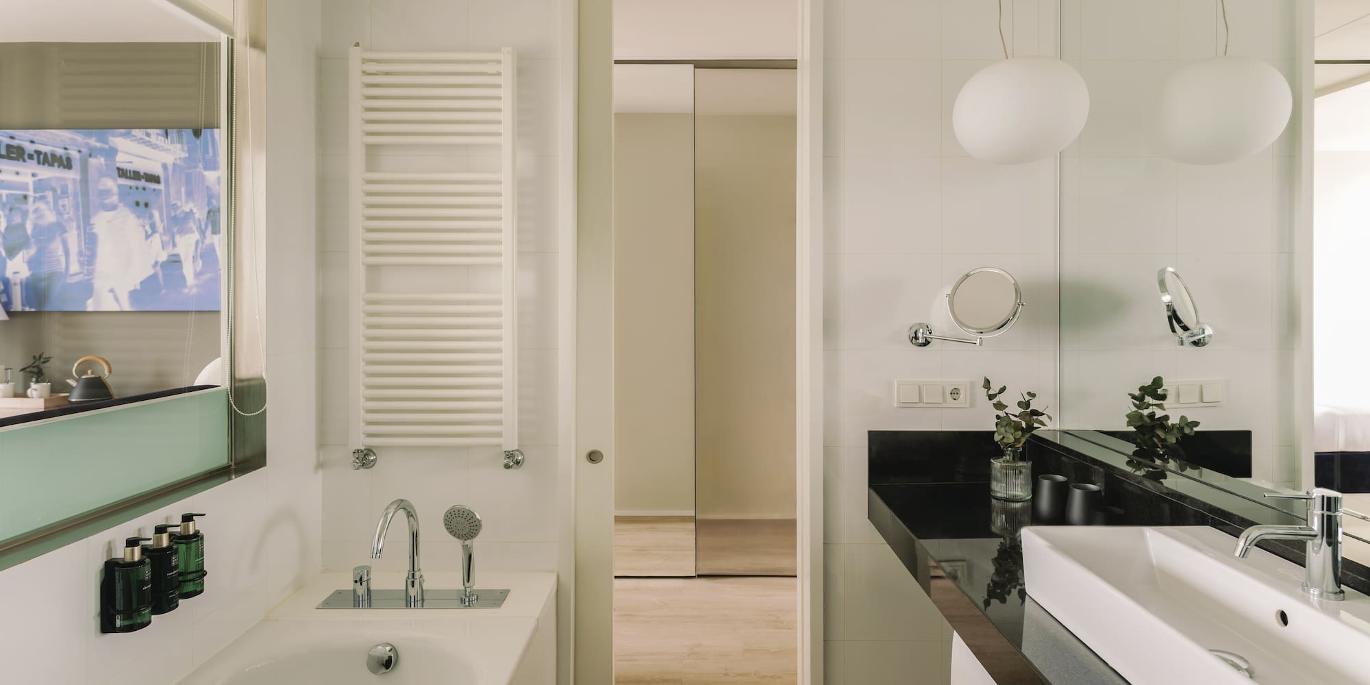 Baño moderno con bañera, lavabo blanco, encimera negra y espejo.
