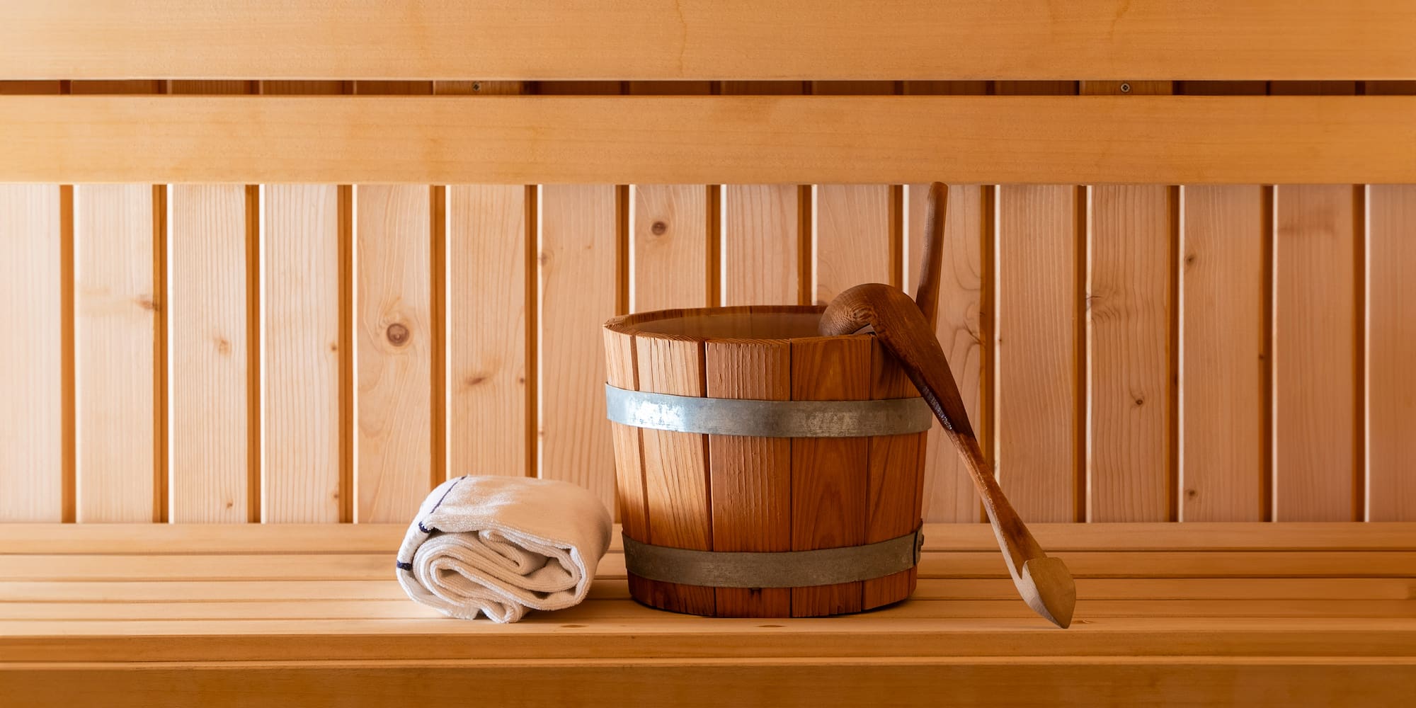 a wooden bucket and towel on a wooden shelf