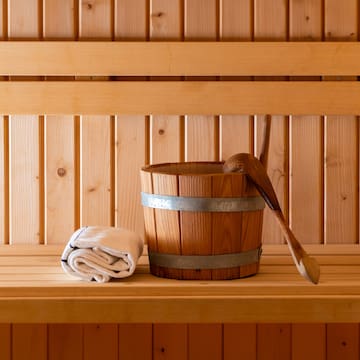 a wooden bucket and towel on a wooden shelf